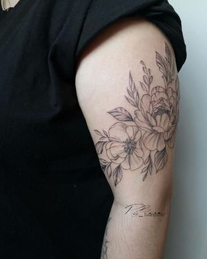 Get the ultimate bold and beautiful blackwork peony tattoo on your upper arm, designed by Patrick Bates.