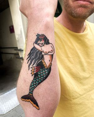 Stunning traditional tattoo featuring a beautiful mermaid and a vibrant flower, expertly done by Lars on the forearm.