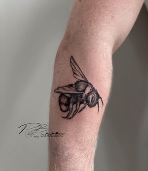 Admire the intricate blackwork bee design by tattoo artist Patrick Bates on your forearm. Stand out with this unique piece!