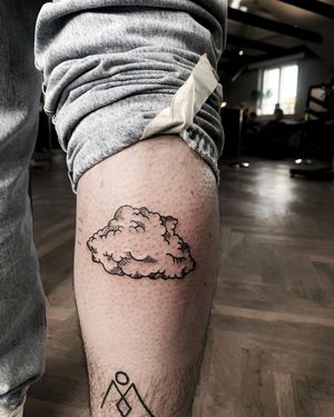 Elegant blackwork and illustrative style tattoo by Lars, featuring intricate fine line clouds on the lower leg.