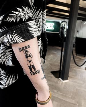 Lars created a striking blackwork forearm tattoo featuring a powerful quote and a bold illustrative woman design.