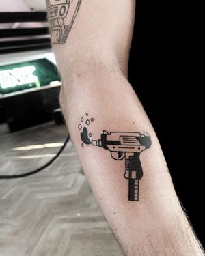 Bold blackwork design of a gun on the forearm, expertly done by artist Lars. Show off your edgy style with this unique tattoo.