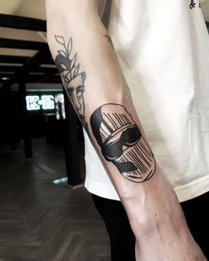 Lars created a stunning blackwork tattoo featuring glasses and a mask on the forearm. Unique and stylish design.