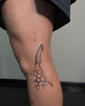 Bold blackwork design featuring a spider, flower, knife, and spider web by artist Yura, perfect for lower leg placement.