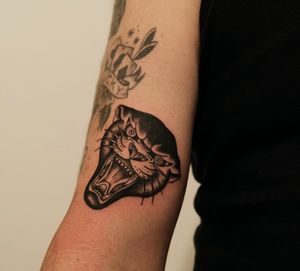 Bold blackwork design of a fierce panther by tattoo artist Yura, perfect for showcasing on your upper arm.