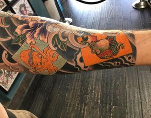 Get inked by the renowned artist Ami James with a stunning design featuring a frog, octopus, toad, flower, and waves in traditional Japanese style.