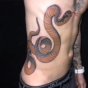 Experience the intricate beauty of a Japanese snake tattoo on your ribs, expertly designed by renowned artist Ami James.
