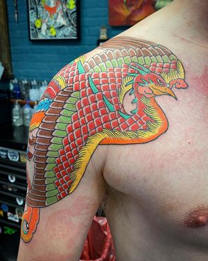 Incredible illustrative phoenix design by Eddy Ospina, beautifully placed on the shoulder for a striking look.