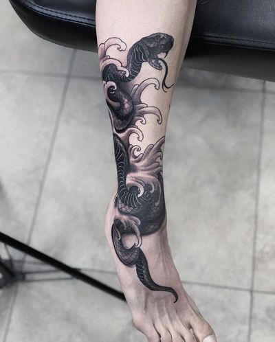 Get a stunning blackwork tattoo of a snake coiled around waves, in a traditional Japanese illustrative style by Marcel Oliveira.