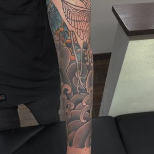 Get a stunning Japanese tattoo on your forearm by the talented artist Ami James, featuring intricate flower and wave motifs.