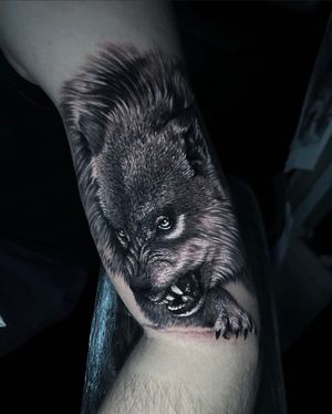 Experience the power of a majestic wolf in this stunning blackwork tattoo on your upper arm, expertly crafted by tattoo artist Marcel Oliveira.