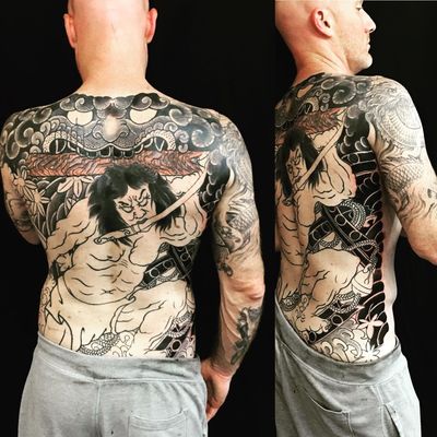 Discover the fierce beauty of a dragon, samurai, and flower in this intricate illustrative tattoo by the talented Ami James.