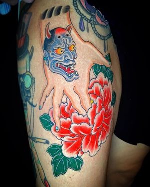 Illustrative tattoo by Eddy Ospina featuring a beautiful Japanese hannya mask, flower, and hand on upper leg.
