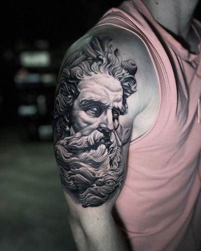 Impressive black and gray tattoo of Poseidon with a man and beard, beautifully executed on the upper arm by talented artist Marcel Oliveira.