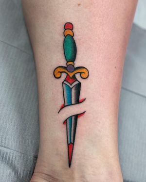 Explore the timeless art of tattooing with a classic dagger design on your forearm. Let Eddy Ospina's skillful hand bring this traditional motif to life.