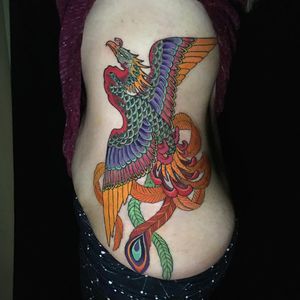 Get a stunning illustrative phoenix tattoo on your ribs, beautifully designed by Ami James.