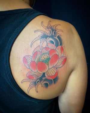 Immerse yourself in the beauty of Japanese art with this illustrative upper back tattoo featuring a stunning combination of flowers and waves.