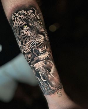 Stunning black and gray forearm tattoo featuring a lifelike elephant and leopard, designed by the talented Marcel Oliveira.