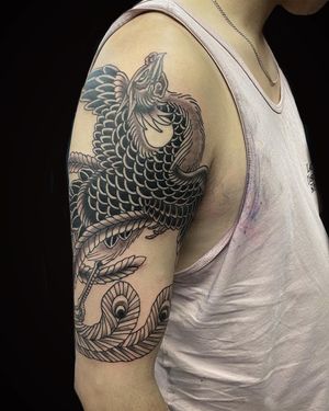 Experience the mythical beauty of a phoenix tattoo by Eddy Ospina, expertly designed for your upper arm. Embrace rebirth and renewal in stunning detail.