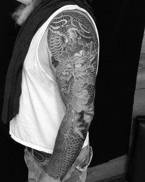 Intricate illustrative design by Ami James featuring a powerful dragon and graceful koi fish motif on a sleeve.