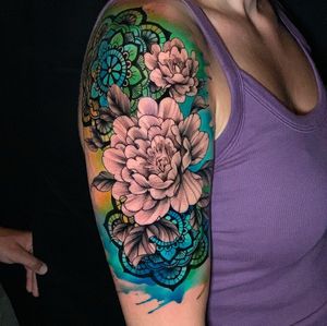 Beautiful upper arm tattoo featuring a intricate peony flower surrounded by a detailed mandala pattern, created by artist Marcel Oliveira.