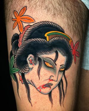 Illustrative tattoo on upper leg featuring a woman with flowers, blood, and namakubi motif