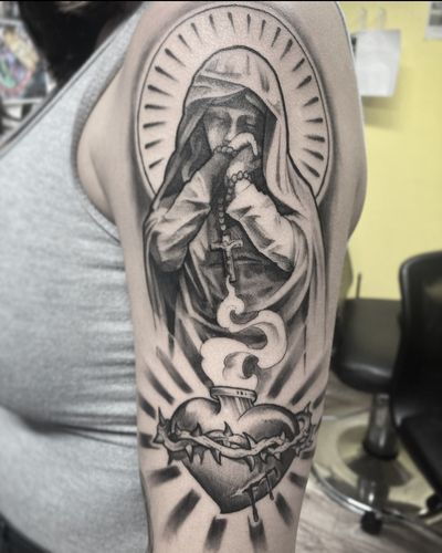 Illustrative design featuring a heart, cross, angel, thorns, fire, flames, and Mary. Created by Rico Dionichi on the upper arm.