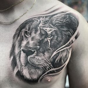 Impressive blackwork and illustrative style tattoo featuring a lion, cross, and Jesus by Rico Dionichi.