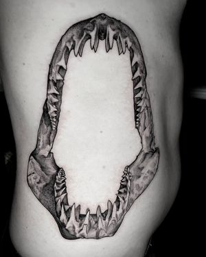 Bold blackwork shark design with sharp teeth, done by the talented Rico Dionichi. A powerful and eye-catching piece for your ribs.