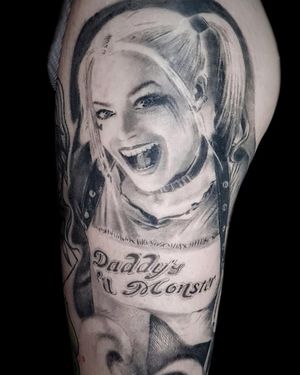 Black and gray realism tattoo of Margot Robbie as Harley Quinn on upper leg by Mauro Imperatori