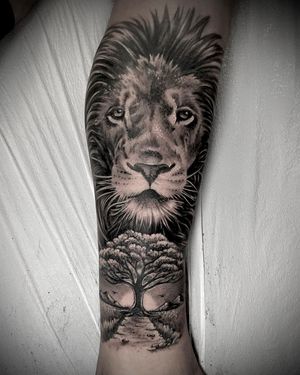 Blackwork and illustrative style tattoo featuring a detailed lion and tree design, created by talented artist Rico Dionichi.