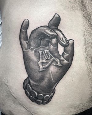Get a stunning black and gray tattoo of a realistic hand holding a letter by talented artist Rico Dionichi.