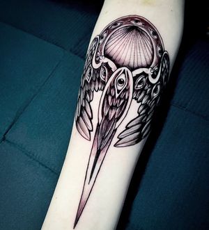 Elegantly detailed wings tattoo by Fernando Joergensen on the forearm, showcasing intricate black and gray shading.