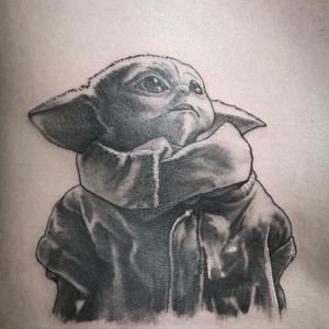 Get inked with this iconic Yoda tattoo in blackwork style by talented artist Rico Dionichi. Perfect for Star Wars fans!