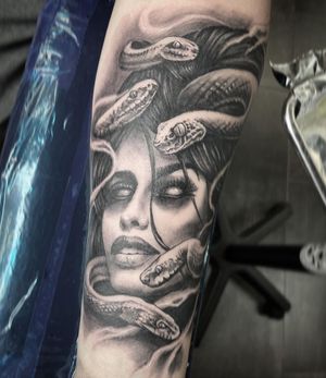Capture the mythical beauty with this striking blackwork design by Rico Dionichi. Featuring a woman intertwined with a snake for a powerful and mesmerizing look.