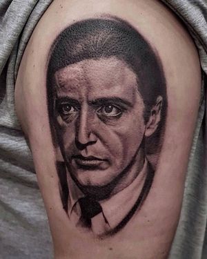 Capture the essence of Al Pacino's iconic style with this black and gray realism tattoo of a suit on the upper arm, by Mauro Imperatori.