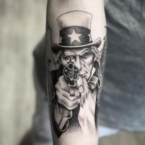 Rico Dionichi's illustrative tattoo combines stars, guns, hats, and revolvers in a bold blackwork design symbolizing loyalty and protection.