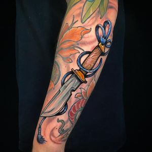 Express your strength with a stunning dagger tattoo on your forearm, meticulously designed by artist Jethro Wood.