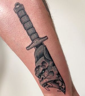 Unique blackwork forearm tattoo by Jethro Wood, featuring a fierce gorilla, playful monkey, and sharp dagger design.