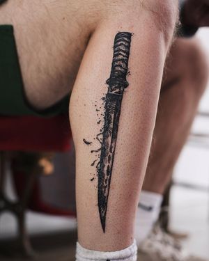 Detailed illustrative dagger tattoo on lower leg by Jamie B. Enjoy the dark charm of blackwork design.
