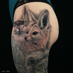 Stunning upper leg tattoo by Marie Terry featuring a majestic sun, cunning fox, and towering tree in detailed black and gray realism.