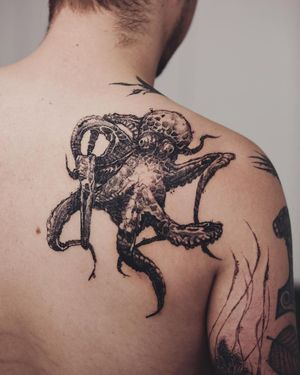 Get mesmerized by Jamie B's blackwork and illustrative style octopus tattoo on your upper back.