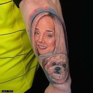 Get a stunning realism tattoo of a dog and a girl on your forearm, done by the talented artist Marie Terry.