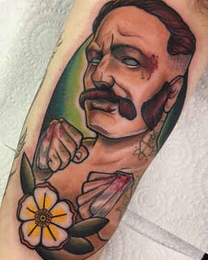 Admire Jethro Wood's masterpiece on upper arm featuring a man with a moustache and a bloodied flower boxing motif.