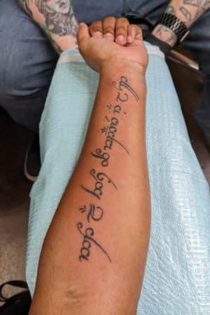 Elvish script that says "Not all those who wander are lost"