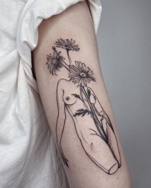 Blackwork illustrative tattoo of a woman with flowers on upper arm, by artist Anna. Bold and beautiful design.