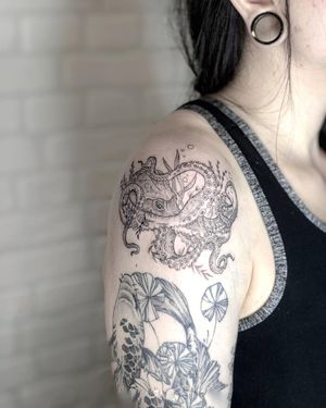 Transform your upper arm with a stunning blackwork octopus tattoo, expertly done by Alisa Hotlib in an illustrative style.