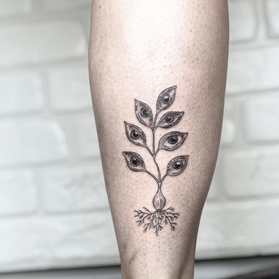 Unique blackwork tattoo on lower leg featuring fruit, eye, and onion motifs by Alisa Hotlib. A masterpiece of illustrative art.