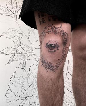 Unique blackwork knee tattoo featuring thorns and a captivating eye, created by renowned artist Alisa Hotlib.