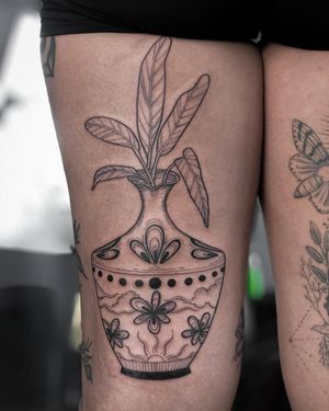 Discover the intricate beauty of blackwork and illustrative styles with this stunning mandala flower vase tattoo by Alisa Hotlib on your upper leg.